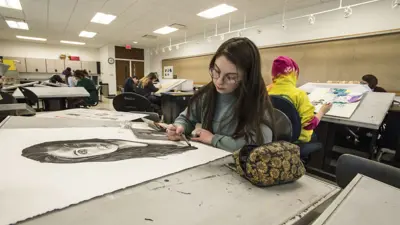 Student draws a portrait in a studio art class