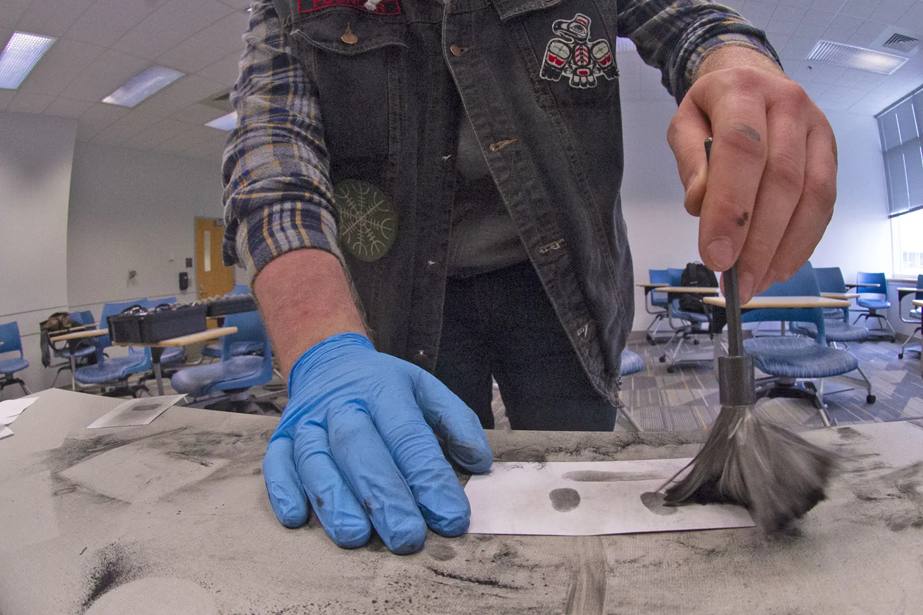 Closeup of a person dusting a notecard for fingerprints