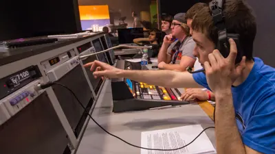 Students work the sound board in the on-campus TV studio