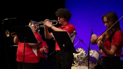 Jazz ensemble members playing instruments at a performance