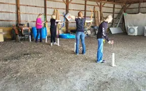 Students practice archery skills during an indoor physical education activity.