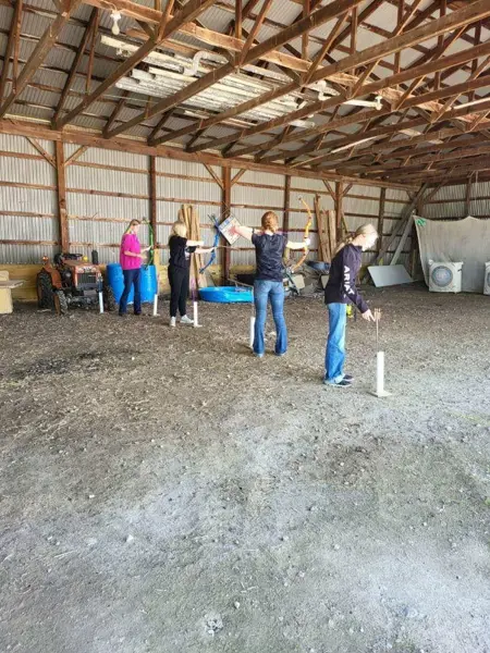 Students practice archery skills during an indoor physical education activity.