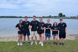 Students pose for a photo with awards in front of a lake in Springfield, Ohio.