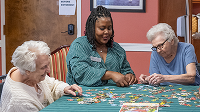 Woman working puzzle with older adults