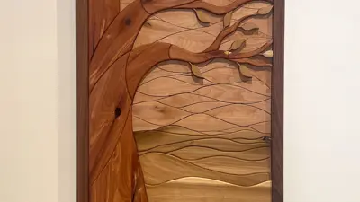 Hanging woodwork sculpture featuring a tree and a horizon