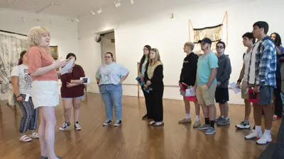 Artist gives a talk as a group watches on in the New Harmony Gallery of Contemporary Art