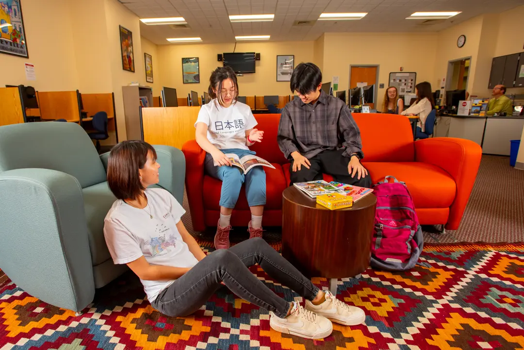 Diverse students sit in a casual seating area in the Language Lab to study