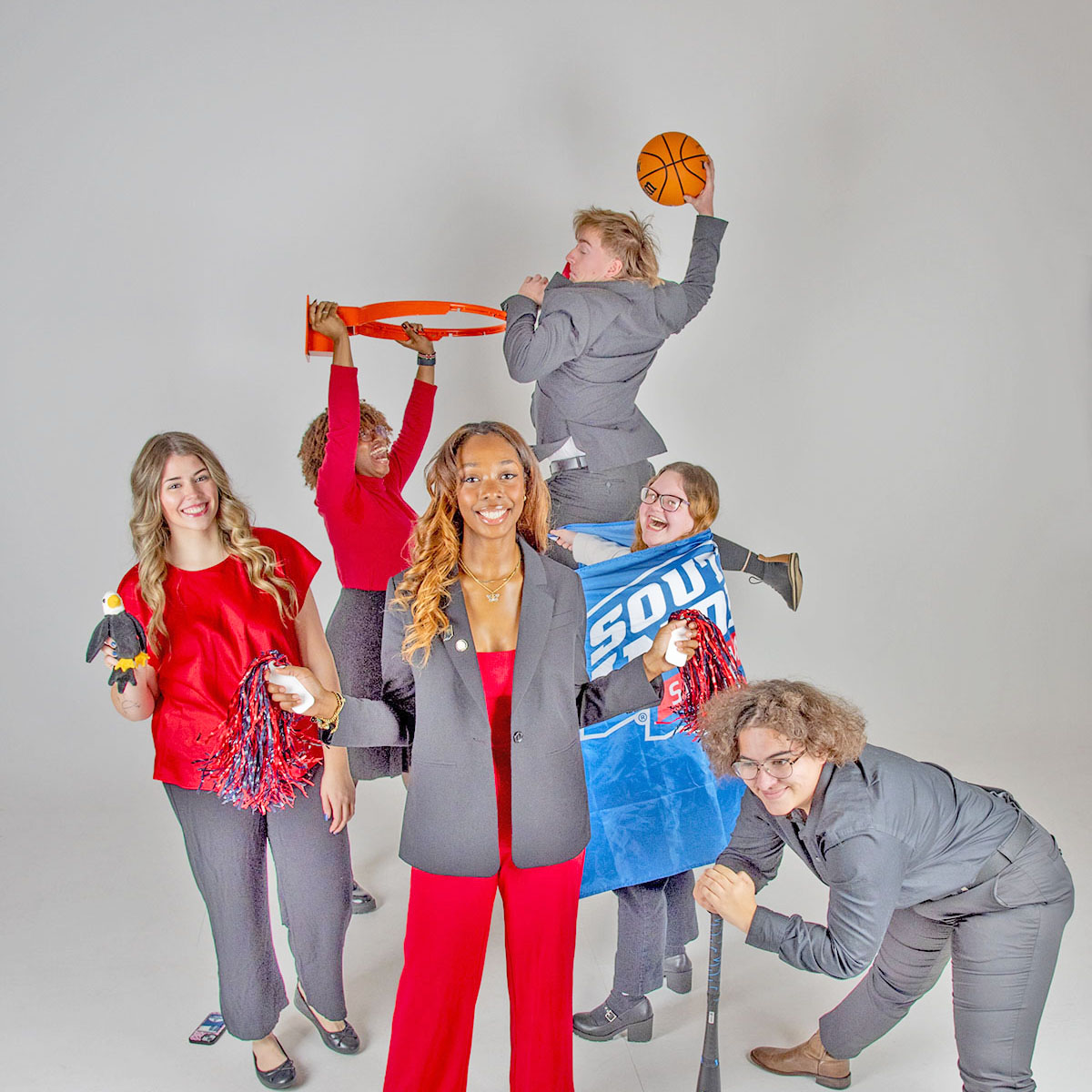 The executive committee of Student Government Association play and cut up with athletic props in the photo studio.