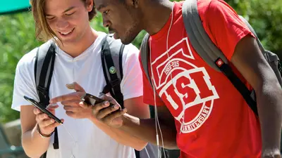 Two students converse while walking to class
