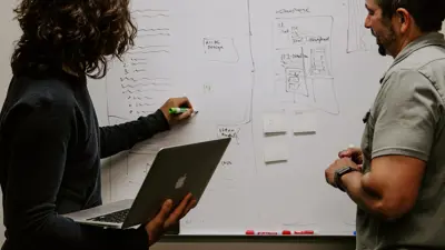 Two people working at a whiteboard