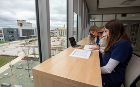 Students studying by a window with view of Downtown Evansville