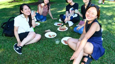 A group of students eat lunch sitting on the Quad
