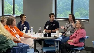 Lunch and learn participants sit around a table having an animated discussion