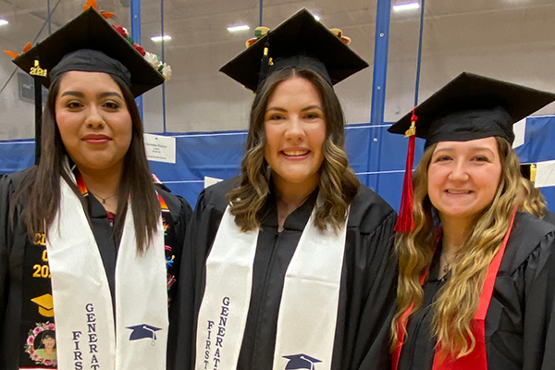 Three Health Administration graduates posing in caps and gowns
