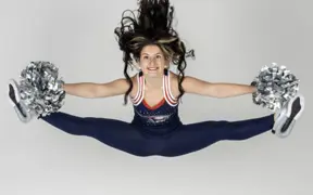 A member of the dance team performs a perfect jump split in the photo studio during their media day.