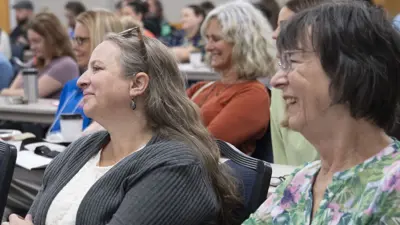 Group of MAIA participants smile at the speaker