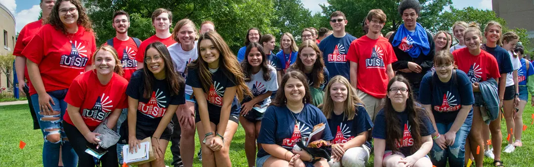 A group of new students at orientation pose in their USI t-shirts