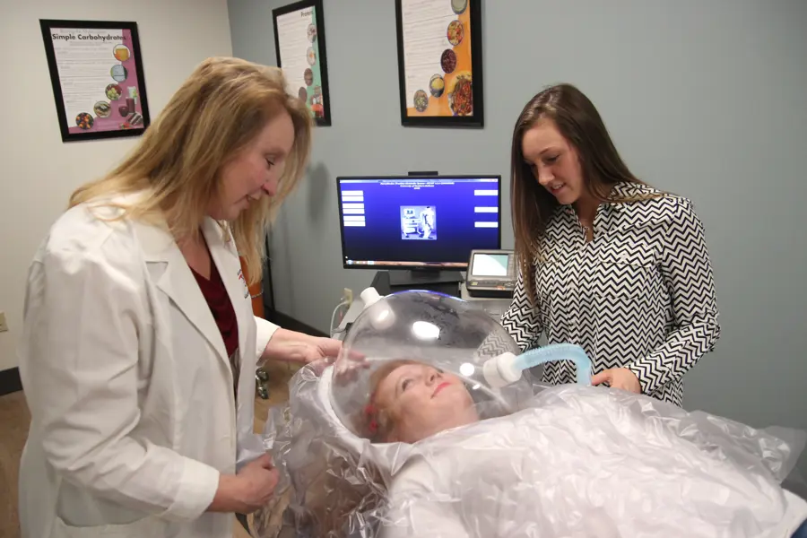 Faculty member and students using equipment 