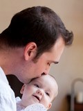 Justin Bigos kissing his baby girl on the forehead