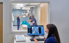 Students working in an X-ray room with monitor on outside showing the X-ray