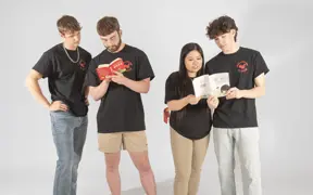 Members of the Chinese Student Union pretend to look at Chinese children's books for their group photo in the photo studio.