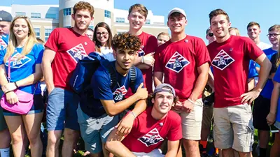 New USI students pose for a group photo on the Quad in their USI t-shirts