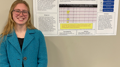Photo of student in front of her poster