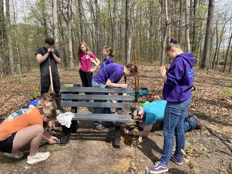 A Scouting Troop helps a 2025 Eagle Scout install some benches on Bent Twig Trail. 