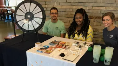 A group of students sit at a table with various wellness giveaways