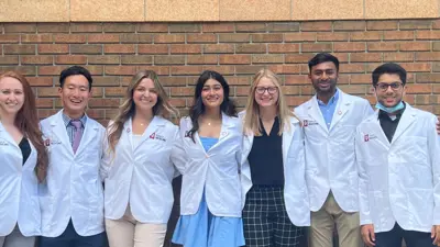 Group of pre-medical sciences students pose in white labs