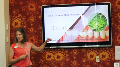 Photo of faculty member pointing to her presentation at a conference