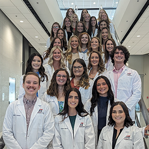 Photo of OT students in white coats on stairs at Stone Family Center