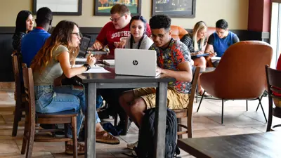 Group of students work on homework together in the Rice Library Lounge