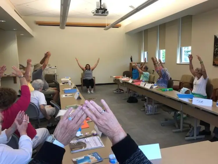 older adults stretching their arms participating in A Matter of Balance class
