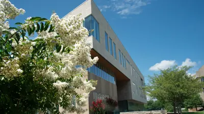 Low angle exterior view of The Business and Engineering Center with a flowering tree in the foreground