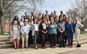 A large group of USI psychology students pose in professional attire with name badges