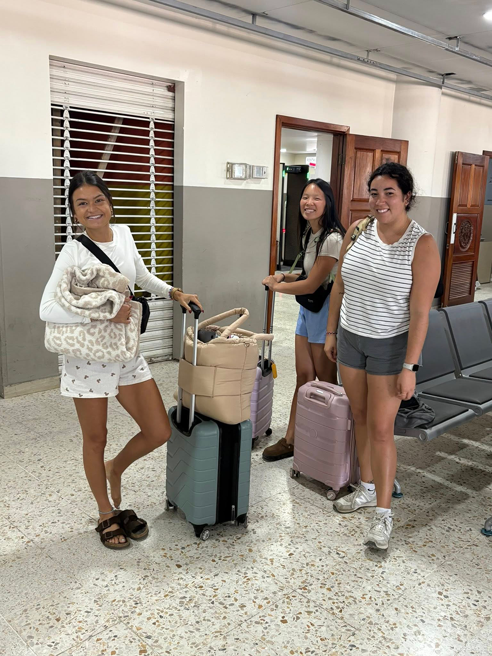 Three OT students with luggage at airport