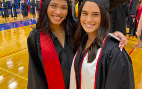 Two food and nutrition wearing graduation caps and gowns