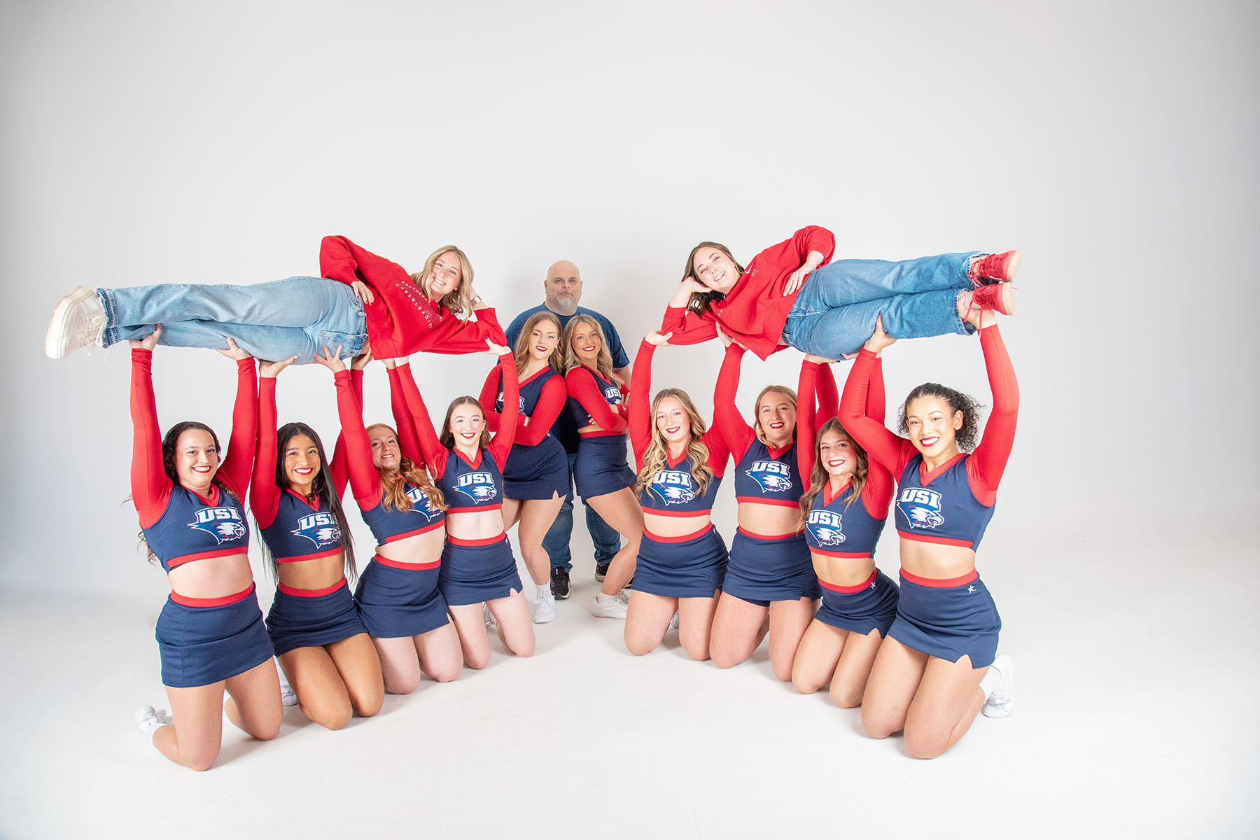 Members of the USI cheer team lift their two long-time coaches in the air. 
