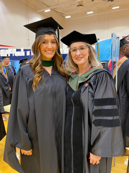MHA student and faculty member in cap and gown