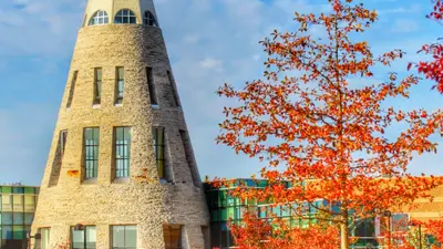 Exterior view of the University Center Tower with trees with fall colors
