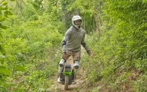 A student on his one wheel motorized scooter on the mountain bike trails. 