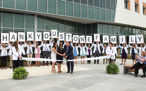 Students holding thank you sign outside the Stone Center during ribbon cutting ceremony