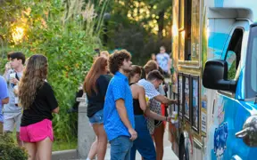 Students stand in line for a food truck at an on-campus event