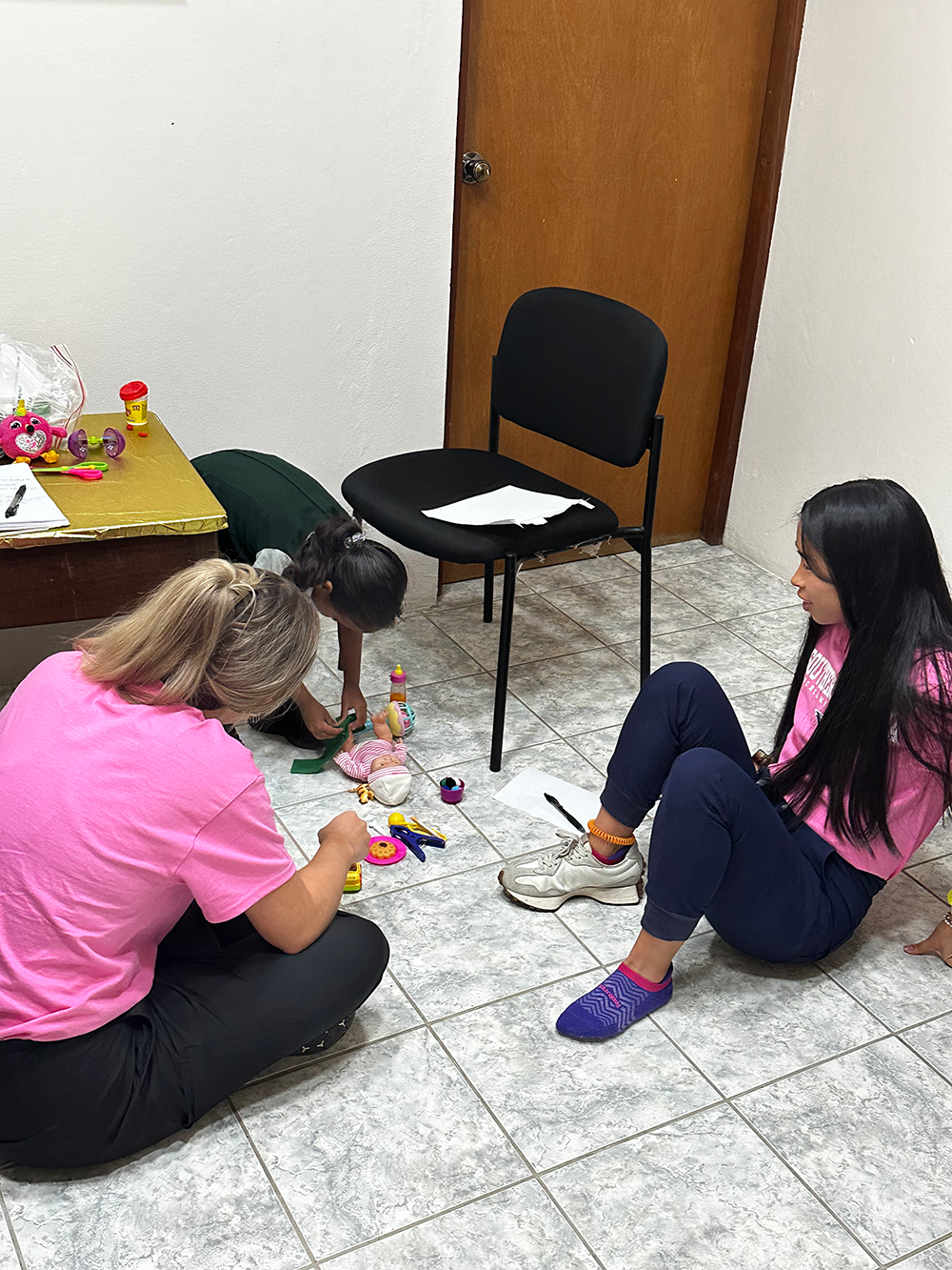 Students sitting on floor with child patient