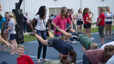 Pott College students do a wheelbarrow challenge at an outdoor event