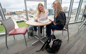Two students at a table studying with view of Downtown Evansville