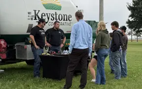 Students engage with Keystone Cooperative representatives during an outdoor agricultural education demonstration.