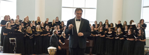 Choir in black attire with accompanist and director in front