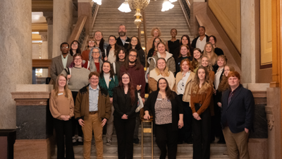 Social work students pose for a group photo on steps